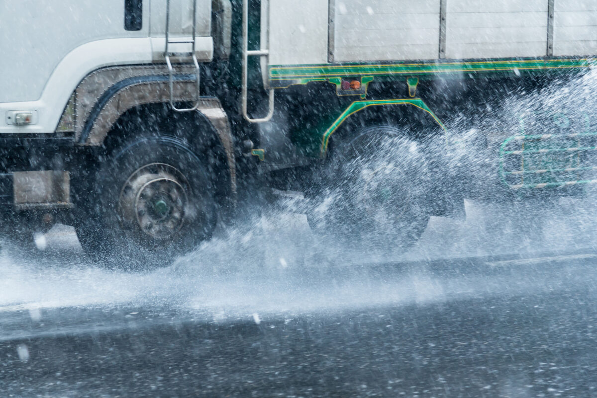 雨の中走るトラックの画像